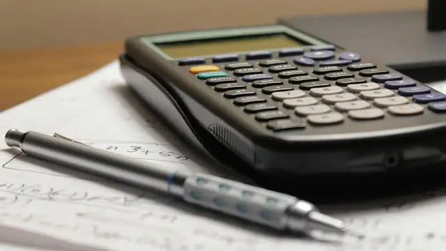 Calculator and pen on paper